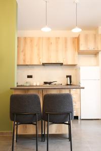 a kitchen with wooden cabinets and a counter with two chairs at Newly Renovated 10 Min To Center in Gomi