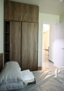a bedroom with a large wooden cabinet and a bed at Newly Renovated 10 Min To Center in Gomi