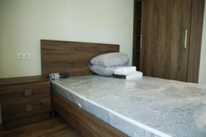 a bedroom with a bed with a wooden headboard at Newly Renovated 10 Min To Center in Gomi +3 photos