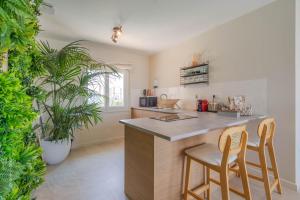 a kitchen with two bar stools and a counter at La Bali, Luxe et relaxation in La Ferté-Gaucher