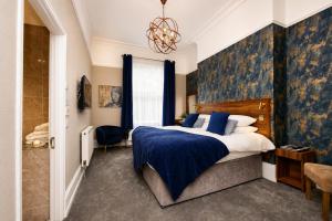 a bedroom with a large bed and a chandelier at Hedley House Hotel Wellness and Spa in York