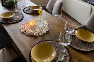 a wooden table with a candle and plates and glasses at Simply Enjoy Ferienwohnungen in Losheim