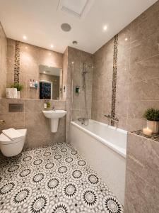 a bathroom with a tub and a toilet and a sink at Hedley House Hotel Wellness and Spa in York