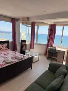 a bedroom with a bed and a desk and a couch at Larnaca Seaview Rooms in Larnaca