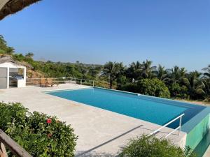 a swimming pool in a resort with palm trees at Les Cases Rouges in Kaolack +9 photos