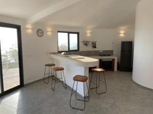 a kitchen with a counter and stools in it at Les Cases Rouges in Kaolack