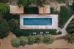 an overhead view of a swimming pool with chairs and trees at Villa MonteLandi in Montalcino