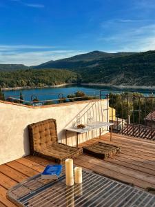 a chair on a deck with a view of a lake at Vue Lac avec Terrasse Privée - "Lani" - Ola Verdon in Bauduen