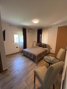 a bedroom with a bed and a table and chairs at Alexandra in Prijevor
