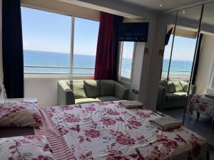 a bedroom with a bed and a view of the ocean at Larnaca Seaview Rooms in Larnaca +11 photos