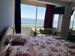 a bedroom with a bed and a view of the ocean at Larnaca Seaview Rooms in Larnaca