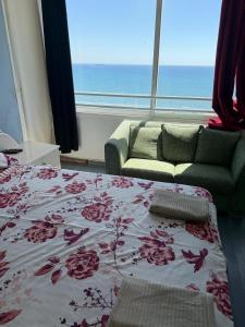 a room with a bed and a couch and a window at Larnaca Seaview Rooms in Larnaca
