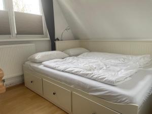 an unmade bed in a room with a window at Ferienhaus Boddenblick in Stahlbrode