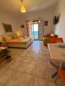 a large living room with two beds and a table at Studios Edem in Agios Ioannis Kaspaka
