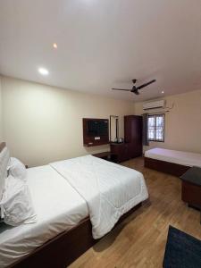 a bedroom with a white bed and a flat screen tv at TSR Grand Hotel in Bhogāpuram