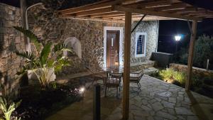 a patio at night with a table and chairs at Stay In Zia in Asfendioú