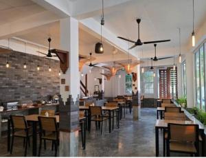 a restaurant with tables and chairs in a room at Rashu Hiyaa Hotel in Dhiffushi