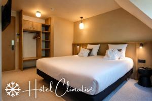 a bedroom with a large bed with white sheets and pillows at Brit Hotel Confort Alençon in Alençon