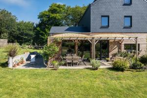 a house with a screened in porch with a patio at L'Oasis d'Yza in Gedinne