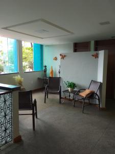 a waiting room with chairs and tables in a building at Hotel Luar de Itapua in Salvador