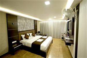 a hotel room with a large bed and a bathroom at HOTEL RUBY PALACE in Tiruchirappalli