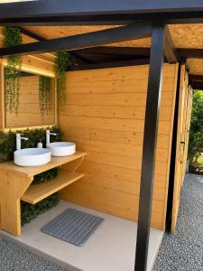 a bathroom with two sinks and a wooden wall at Bulamac Luxury Glamping in Vama Veche