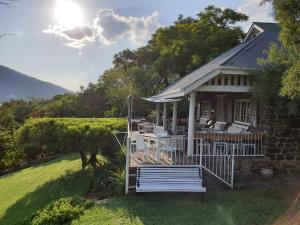 a house with a porch and a view of a vineyard at Guesthouse 1921 in Hartbeespoort
