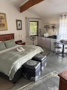 a bedroom with a large bed and a kitchen at Guesthouse 1921 in Hartbeespoort