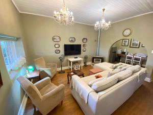 a living room with a large white couch and chairs at Guesthouse 1921 in Hartbeespoort