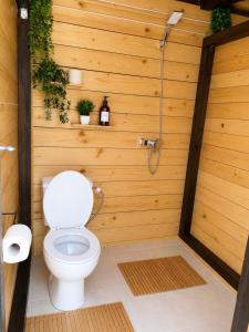 a bathroom with a toilet in a wooden wall at Bulamac Luxury Glamping in Vama Veche