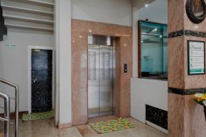 a elevator with a glass door in a building at Treebo Ksheera Residency Near Railway Station in Hassan