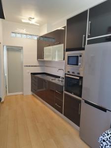 a kitchen with stainless steel appliances and brown cabinets at Casa Bela in Sagres