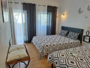 a bedroom with two beds and a chair at Casa Bela in Sagres