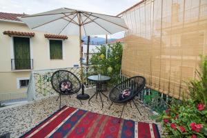 a patio with two chairs and a table and an umbrella at Thalgiron, a breath away from Delphi in Ámfissa +14 photos