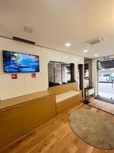 a living room with a couch and a tv on the wall at Seculo Hotel in Porto