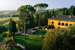 an aerial view of a yellow house in a field at Villa MonteLandi in Montalcino