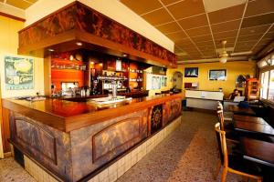 a bar with a wooden counter in a restaurant at Hotel le Bon Soleil in Les Sables-d'Olonne