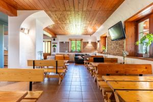 ein Restaurant mit Holztischen und -bänken in der Unterkunft Pod Orlicą in Duszniki-Zdrój
