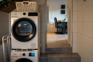 a washer and dryer in a room with a kitchen at Shaft by Loftigo - Apartment mit Wellnessdusche in Übach-Palenberg