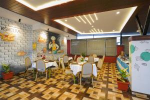 a restaurant with tables and chairs in a room at Treebo Ksheera Residency Near Railway Station in Hassan