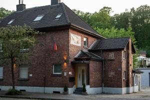 a red brick house with a black roof at Shaft by Loftigo - Apartment mit Wellnessdusche in Übach-Palenberg