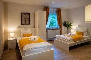 a bedroom with two beds and a window at Shaft by Loftigo - Apartment mit Wellnessdusche in Übach-Palenberg