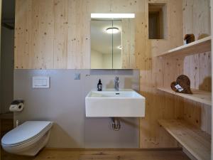 a bathroom with a white sink and a toilet at Holz100 Kleinhaus in Attinghausen
