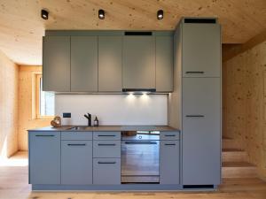 a kitchen with white cabinets and a sink at Holz100 Kleinhaus in Attinghausen +9 photos