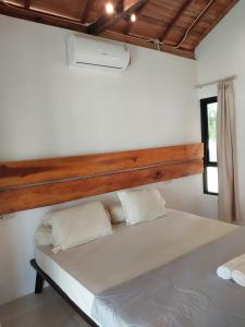 a bedroom with a large bed with a wooden headboard at Slab Krui Bungalows in Krui