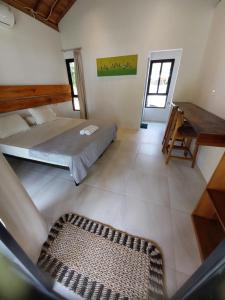 a living room with a bed and a piano at Slab Krui Bungalows in Krui +2 photos