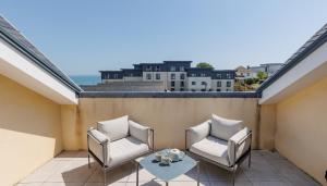 a balcony with two chairs and a table on a roof at Seagrass in Sandown