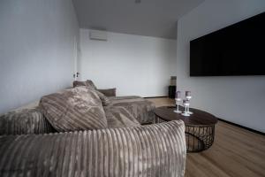 a living room with a couch and a table with wine glasses at Sodyba Biruta in Tautrimai