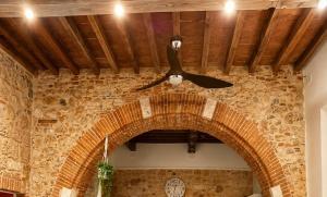 a ceiling fan in a room with a brick wall at La Casina del Corso in Massa Marittima +28 photos