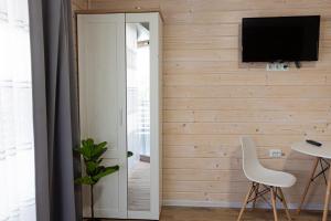 a living room with a television on a wall at LOTUS Hotel Solotvino in Solotvyno